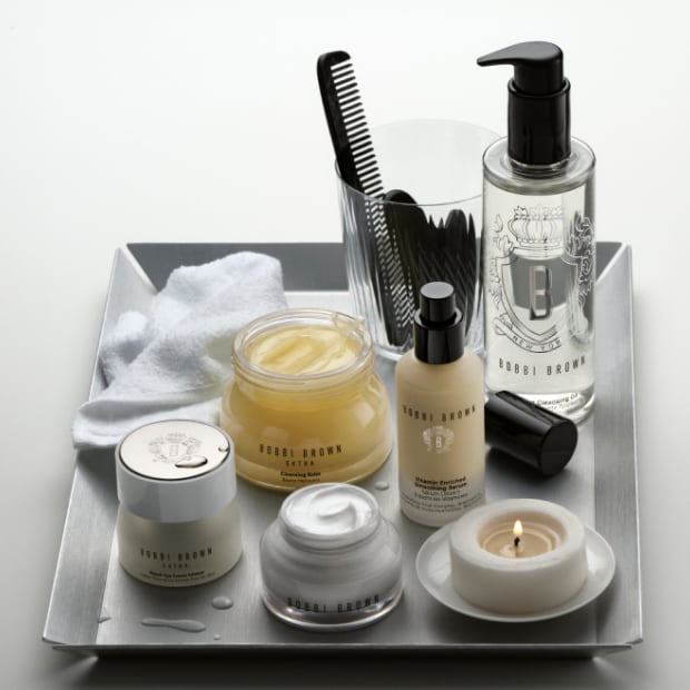 Model applying Skin Long-Wear Weightless Foundation to skin with a foundation brush